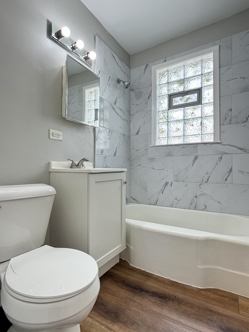 17826 School Street Lansing, IL 60438 - Photo 9 of 23 a bathroom with a toilet a sink and bathtub