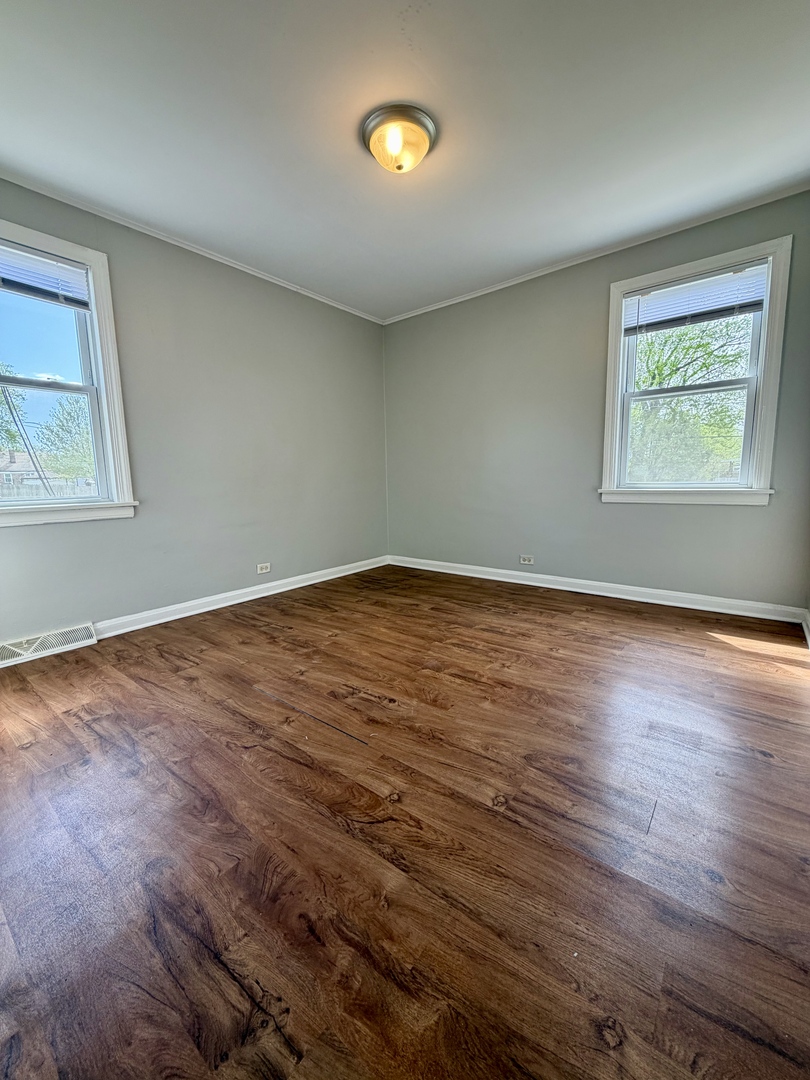 17826 School Street Lansing, IL 60438 - Photo 10 of 23 an empty room with wooden floor and windows