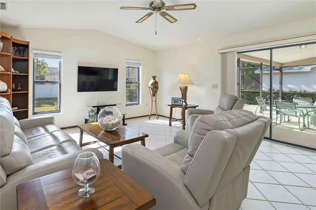 a living room with furniture a flat screen tv and a large window