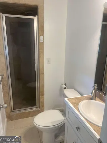 a bathroom with a granite countertop toilet a sink and a mirror
