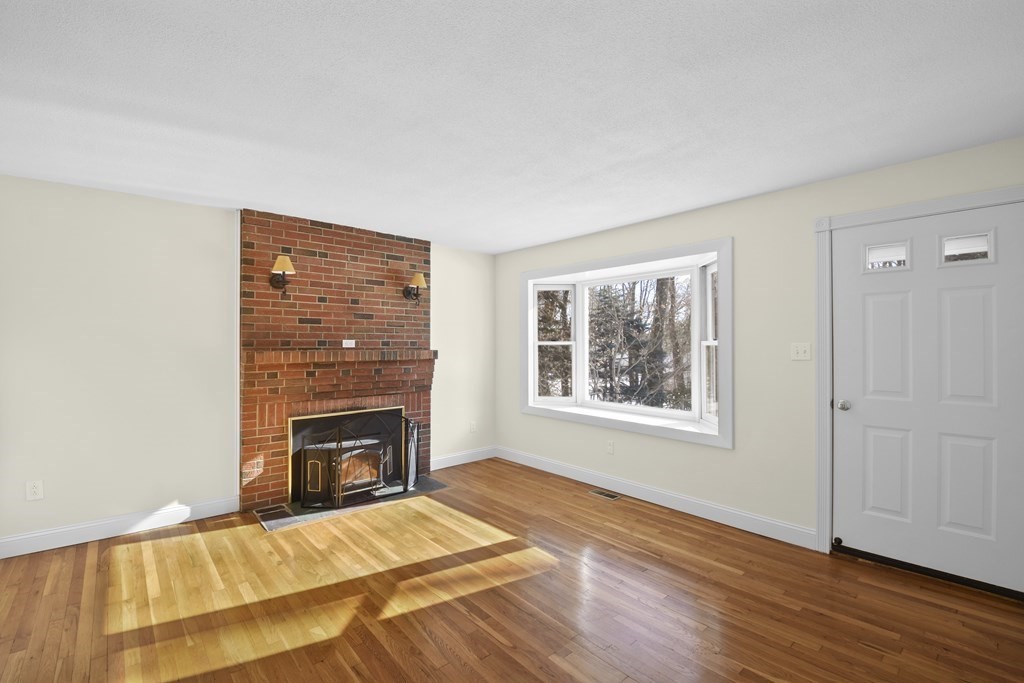 45 Bay Path Road Charlton, MA 01507 - Photo 3 of 35 a view of an empty room with wooden floor fireplace and a window