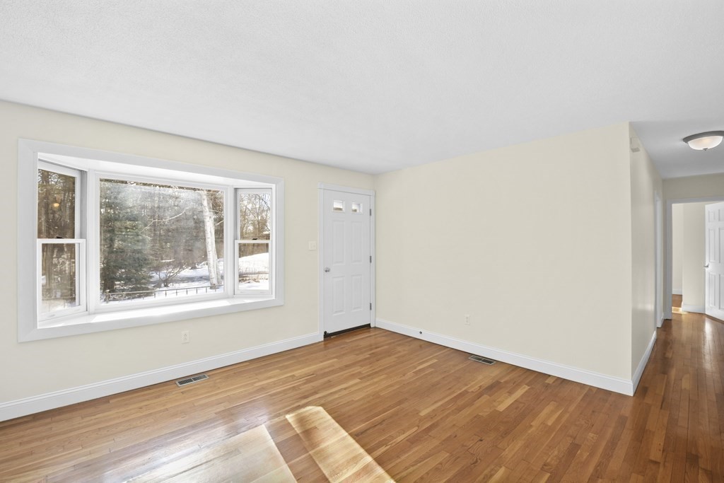 45 Bay Path Road Charlton, MA 01507 - Photo 4 of 35 an empty room with wooden floor and windows