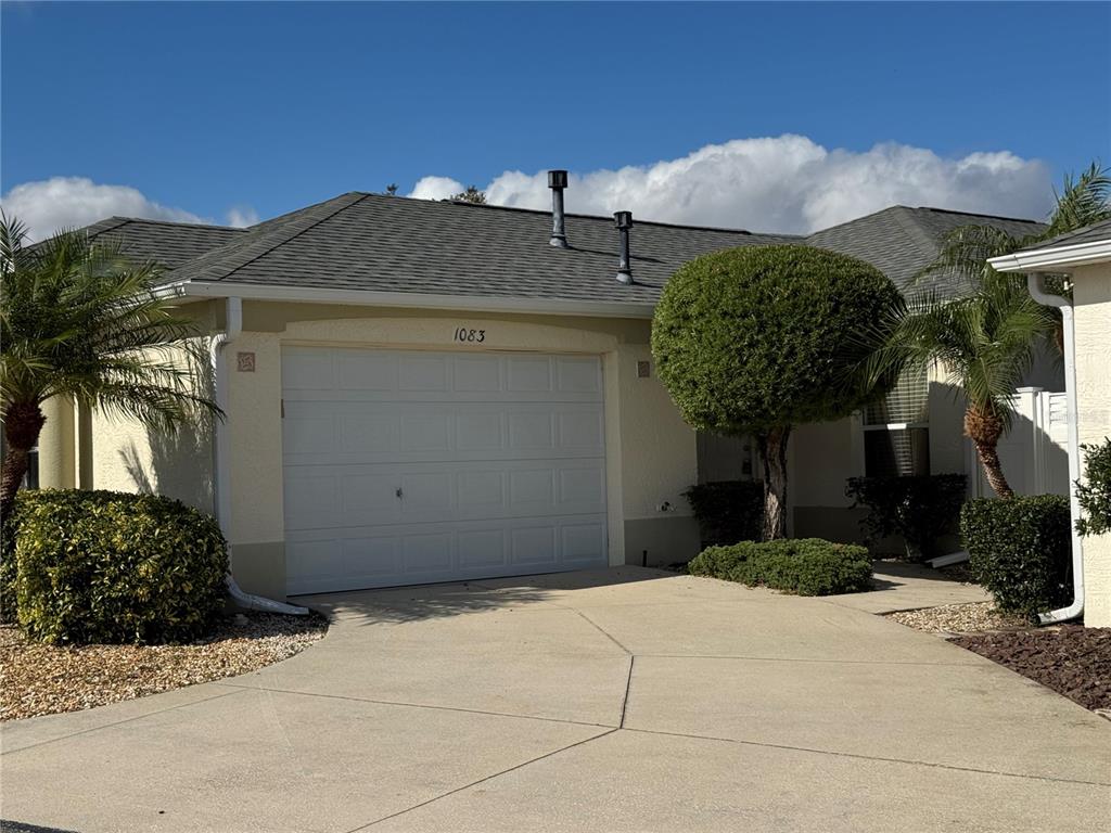 1083 Jackson Street The Villages, FL 32162 - Photo 1 of 15 a front view of a house with a yard and garage
