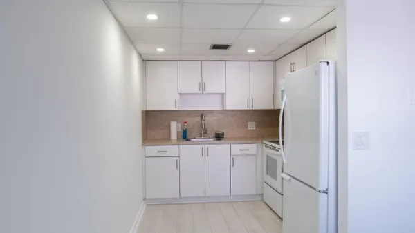 a kitchen with white cabinets and white appliances