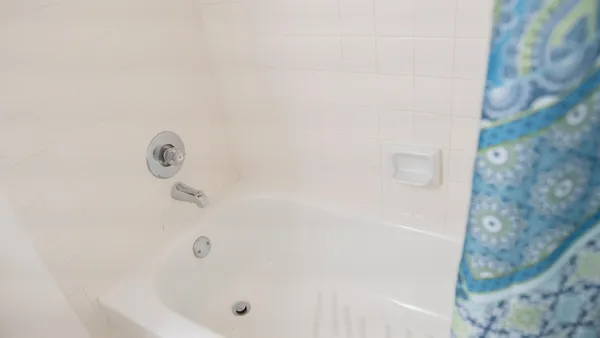 a white toilet sitting next to a bath tub shower