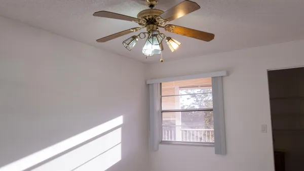 a view of a room that has a window and a fan