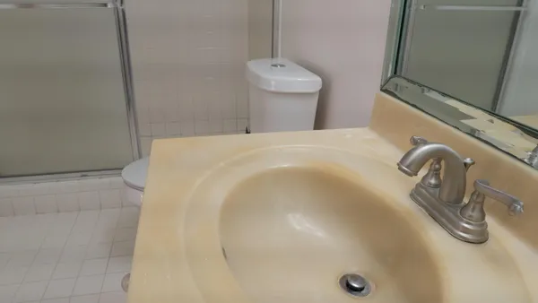 a view of a room with a ceiling fan and a window