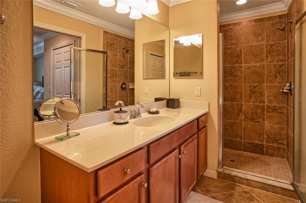 9727 Acqua Court, Unit 425 Naples, FL 34113 - Photo 11 of 26 a bathroom with a sink shower and a mirror