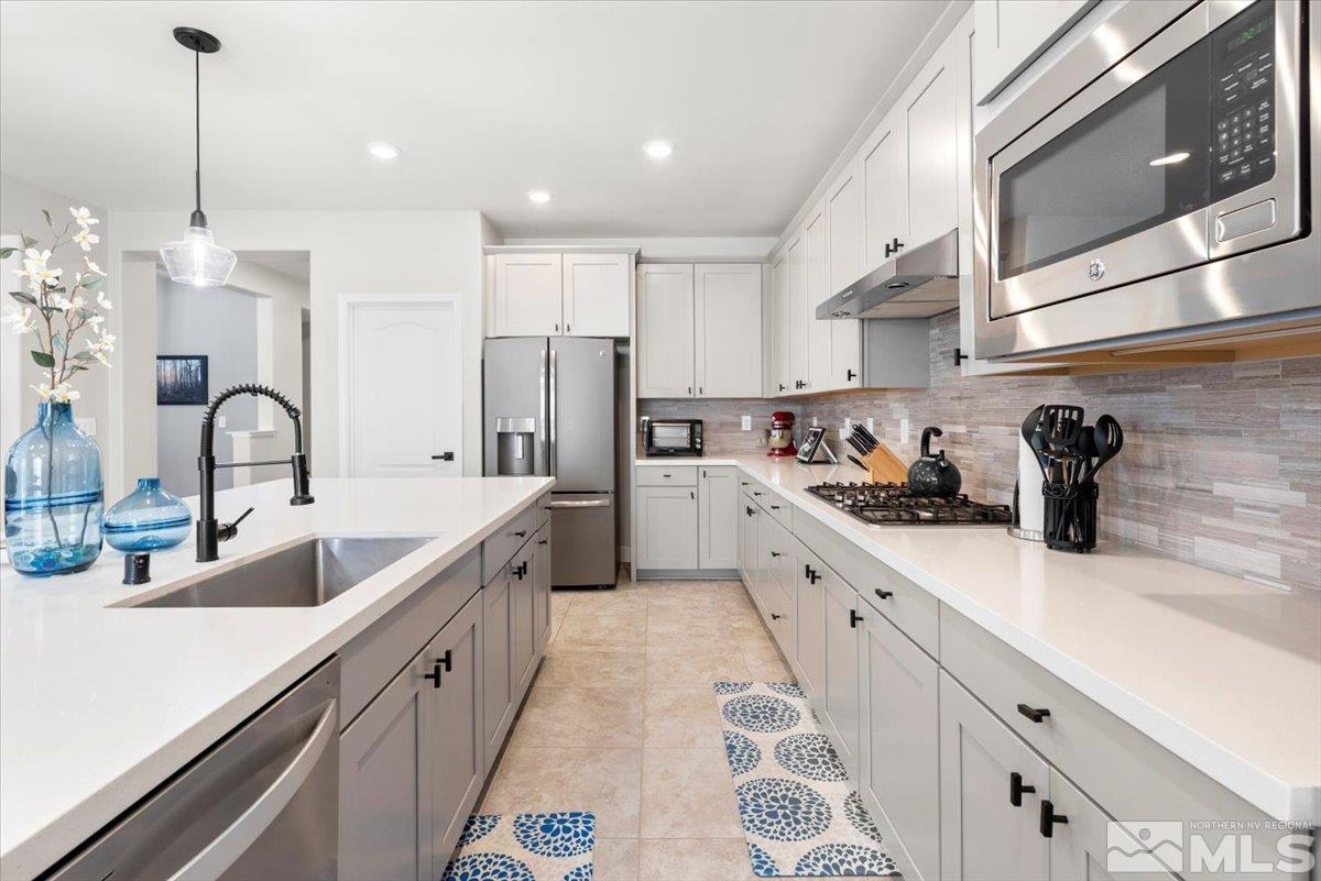 2711 McCauley Ranch Boulevard Reno, NV 89521 - Photo 14 of 40 a kitchen with stainless steel appliances granite countertop a sink a stove and a refrigerator