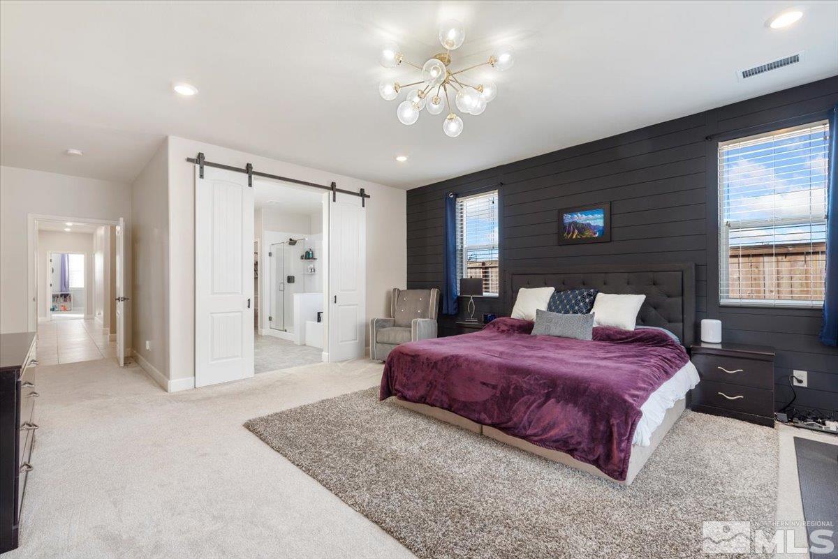 2711 McCauley Ranch Boulevard Reno, NV 89521 - Photo 18 of 40 a spacious bedroom with a large bed a chandelier and closet