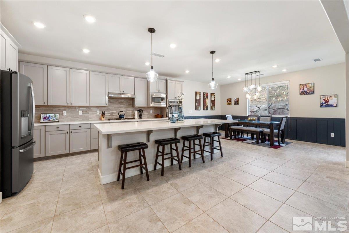 2711 McCauley Ranch Boulevard Reno, NV 89521 - Photo 10 of 40 a kitchen with stainless steel appliances a sink a stove a refrigerator cabinets and chairs