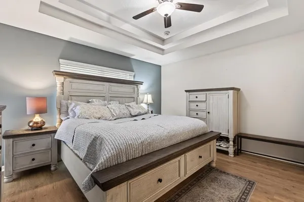 a spacious bedroom with a bed and a chandelier