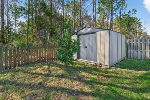 a view of a backyard with barn and wooden fence