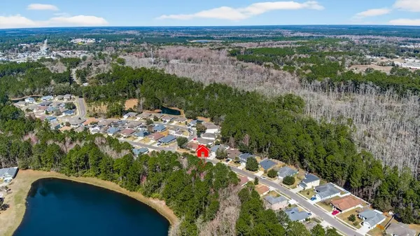 an aerial view of residential houses with outdoor space and trees