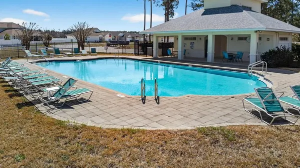 a view of a house with a swimming pool and a yard