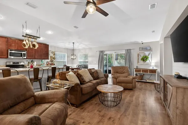 a living room with furniture kitchen view and a window