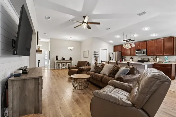 a living room with stainless steel appliances kitchen island granite countertop a couch and a view of kitchen