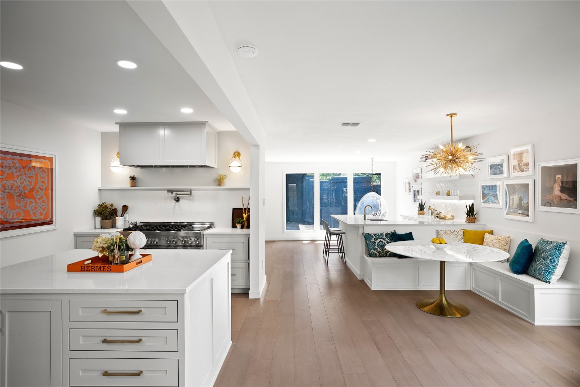a living room with stainless steel appliances furniture a rug and a kitchen view