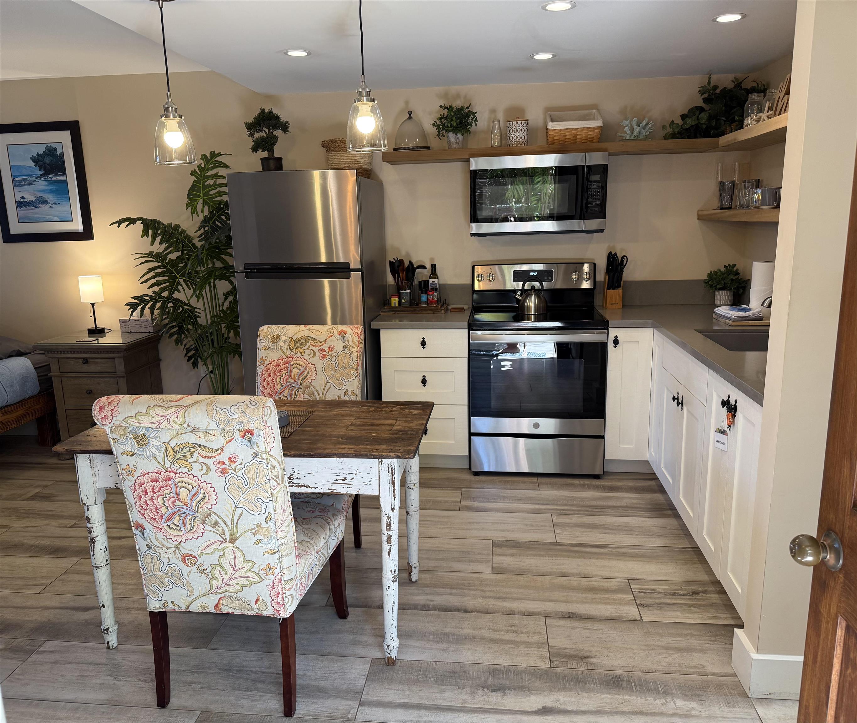 120 Hui F Road, Unit J1 Lahaina, HI 96761 - Photo 3 of 36 a kitchen with stainless steel appliances kitchen island granite countertop a table chairs and a refrigerator