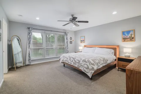 a spacious bedroom with a bed and a large window