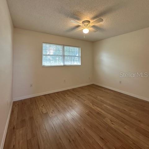 525 South Conway Road, Unit 51 Orlando, FL 32807 - Photo 13 of 18 an empty room with wooden floor chandelier fan and windows