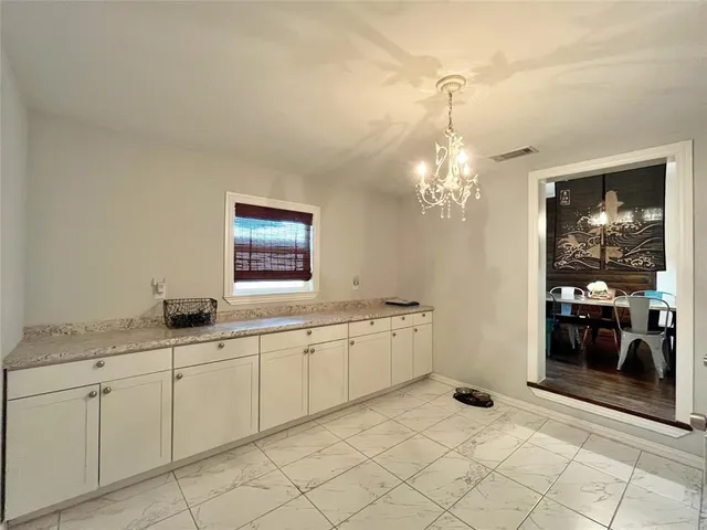 a spacious bathroom with a granite countertop sink a mirror and a vanity