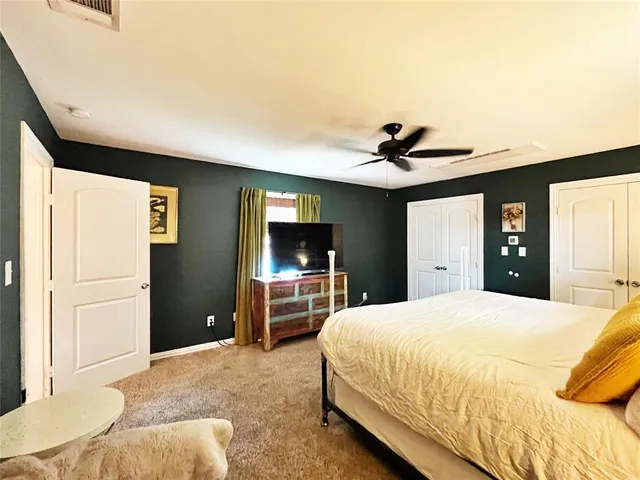 a bedroom with a bed and a dresser with mirror
