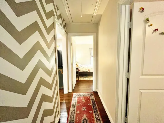 a view of a hallway with wooden floor and stairs