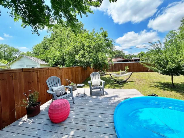 a view of a deck with table and chairs with wooden floor and fence