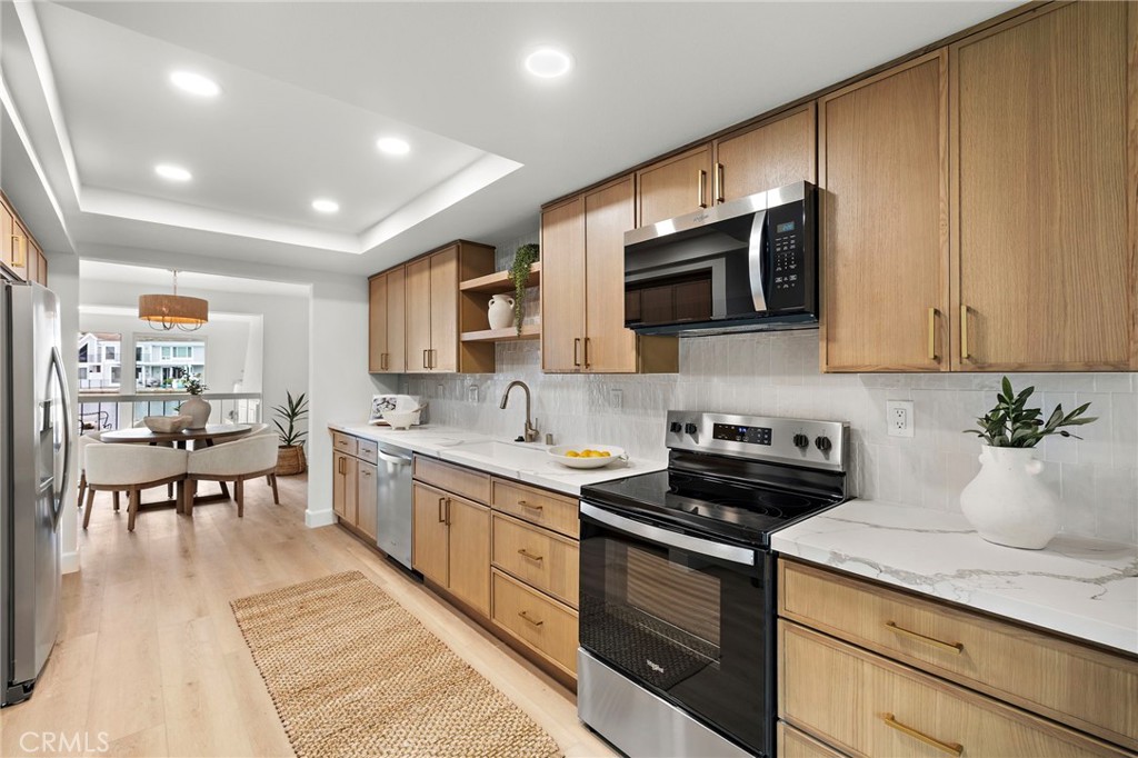 16103 St Croix Circle Huntington Beach, CA 92649 - Photo 4 of 40 a kitchen with stainless steel appliances granite countertop a stove a sink and a microwave
