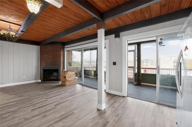 a view of empty room with wooden floor and fireplace