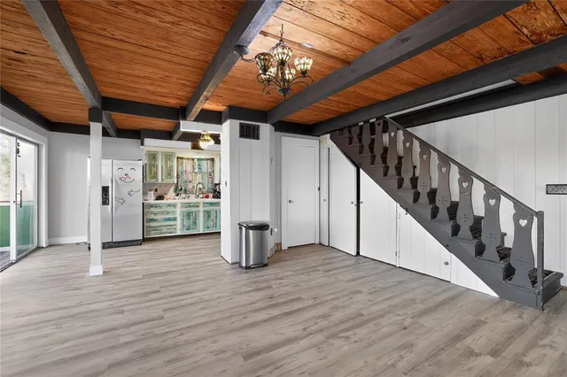 a view of a livingroom with wooden floor and stairs