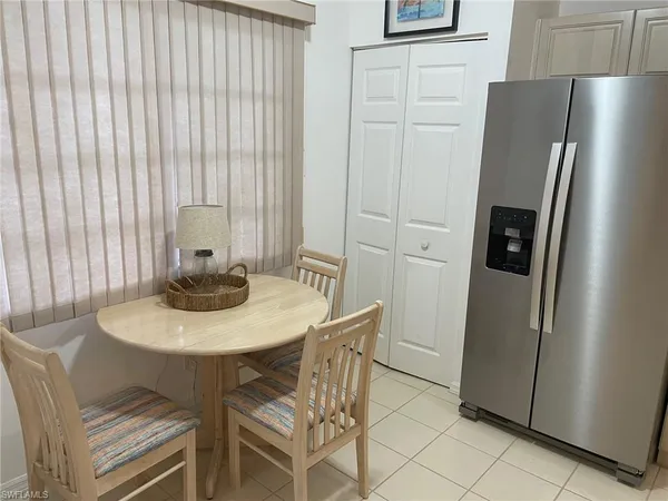 a kitchen with stainless steel appliances a refrigerator a table and a refrigerator