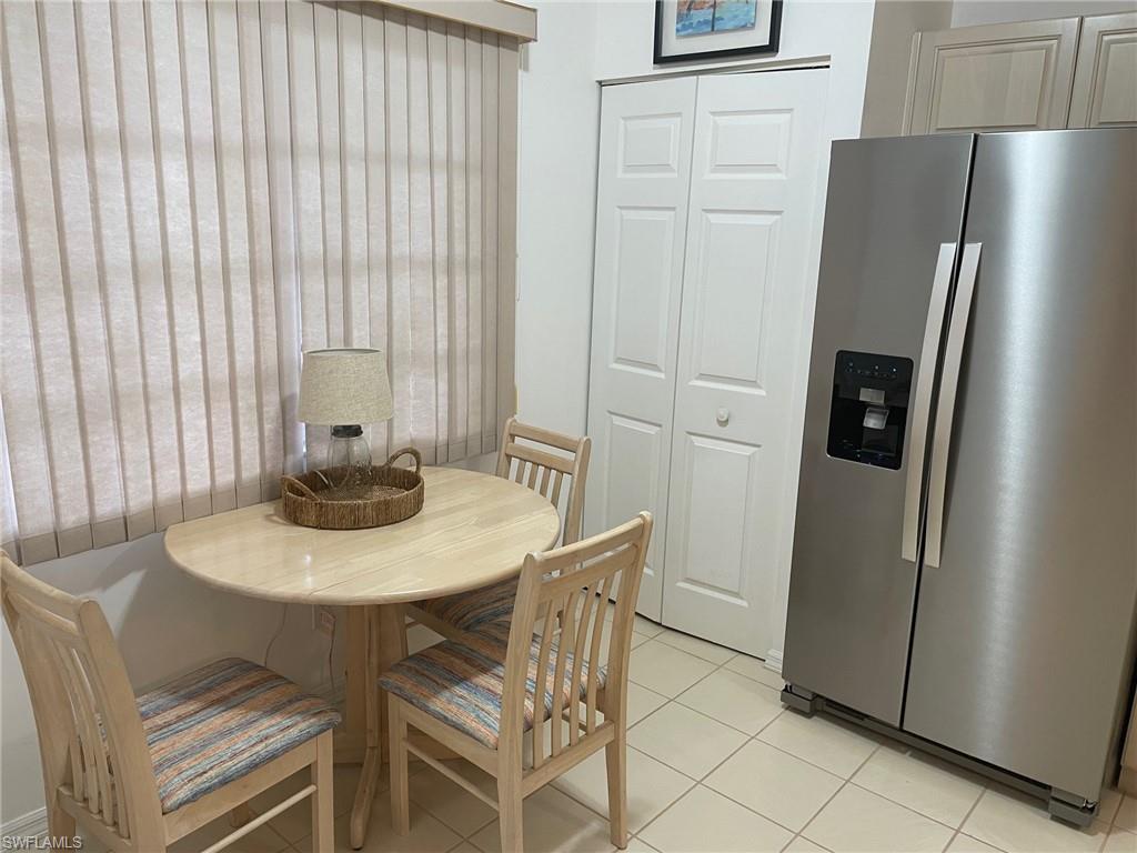 9022 Michael Circle, Unit 2205 Naples, FL 34113 - Photo 11 of 26 a kitchen with stainless steel appliances a refrigerator a table and a refrigerator