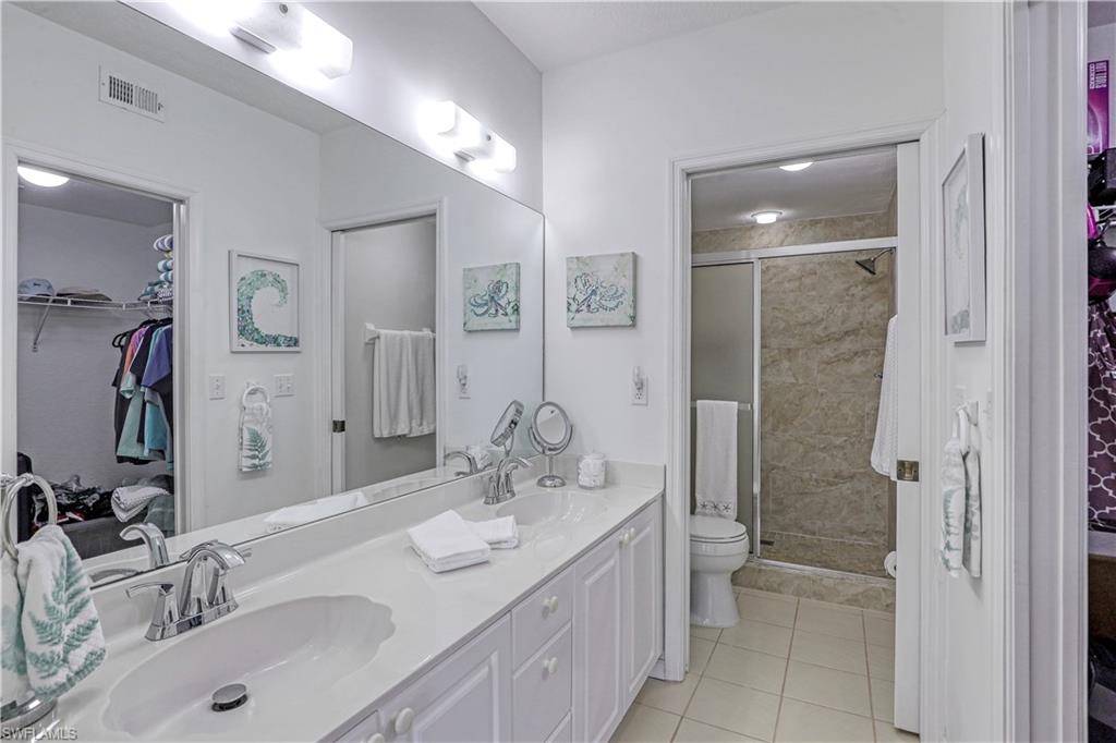 9022 Michael Circle, Unit 2205 Naples, FL 34113 - Photo 13 of 26 a bathroom with a sink double vanity and a shower