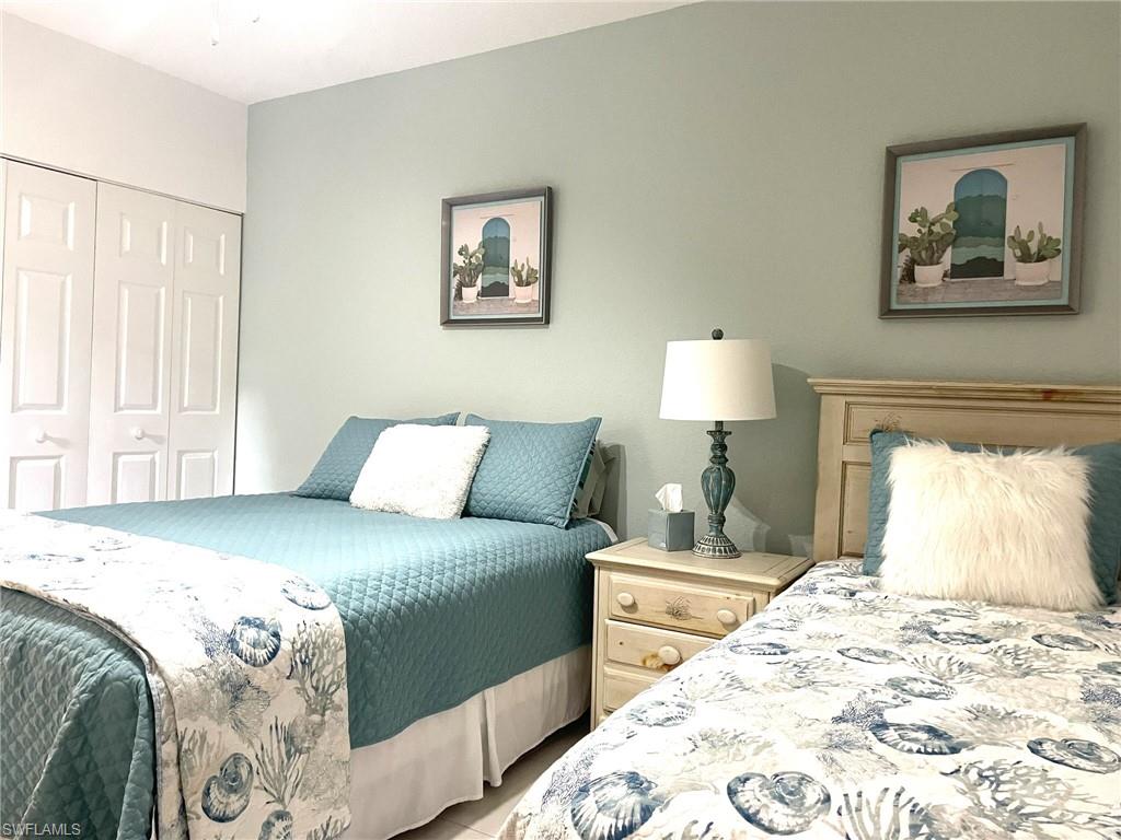 9022 Michael Circle, Unit 2205 Naples, FL 34113 - Photo 16 of 26 a bedroom with a bed and a lamp