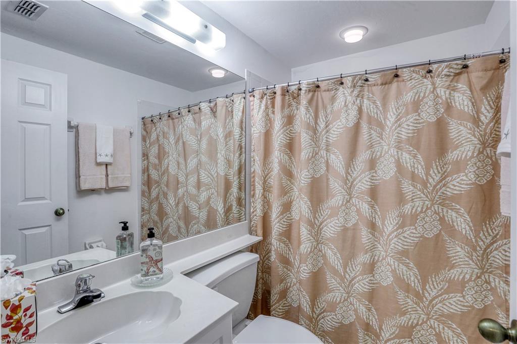 9022 Michael Circle, Unit 2205 Naples, FL 34113 - Photo 17 of 26 a bathroom with a sink and a mirror