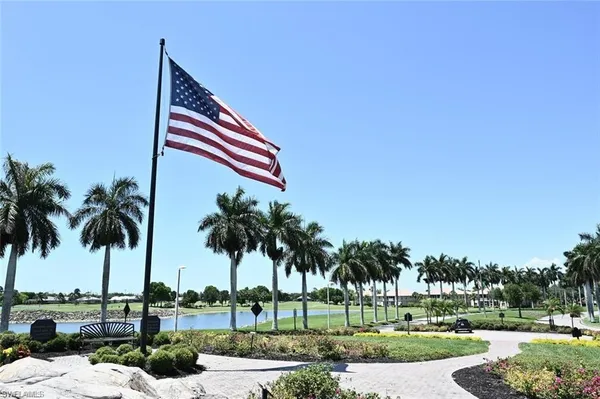 a front view of a house with a yard and palm trees