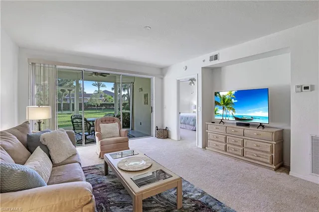 a living room with furniture a large window and a flat screen tv