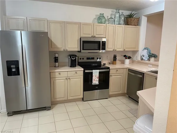 a kitchen with stainless steel appliances a refrigerator sink and microwave