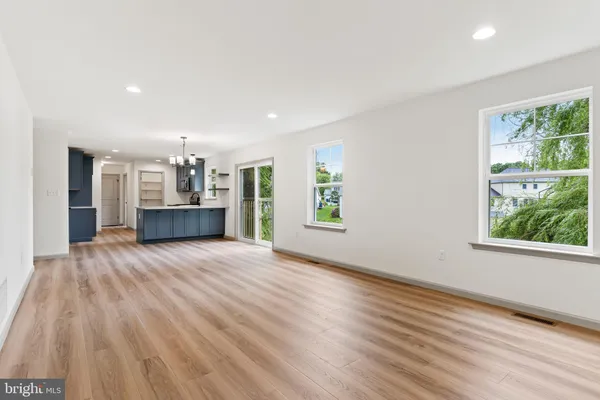 a view of empty room with kitchen and window