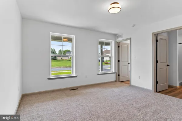 an empty room with windows and closet