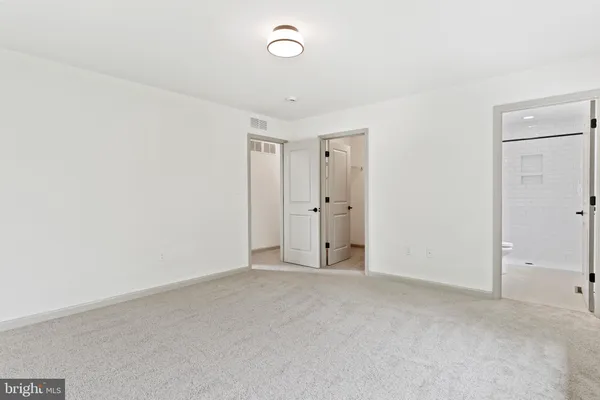 an empty room with an entryway and closet area