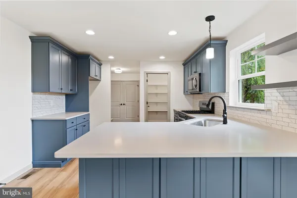 a large kitchen with kitchen island a sink stainless steel appliances and cabinets