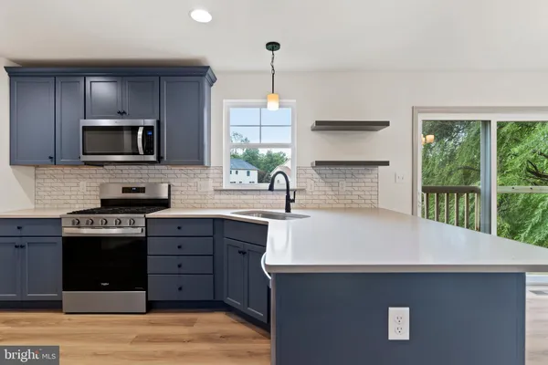 a kitchen with a sink stove and microwave