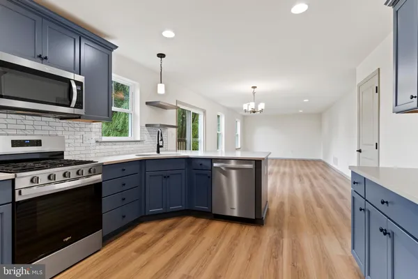 a kitchen with stainless steel appliances granite countertop wooden cabinets stove top oven and sink