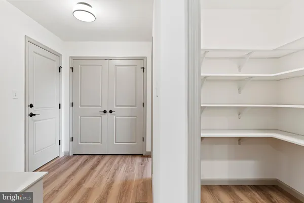 a view of a room with a closet and wooden floor