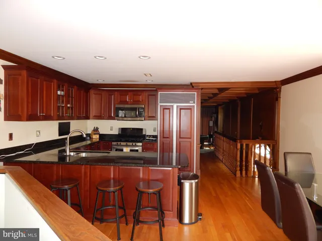 a kitchen with stainless steel appliances granite countertop a sink refrigerator and cabinets