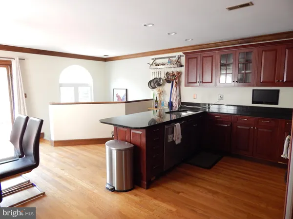 a kitchen with a sink cabinets and wooden floor
