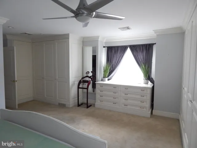 a view of room with window and a ceiling fan